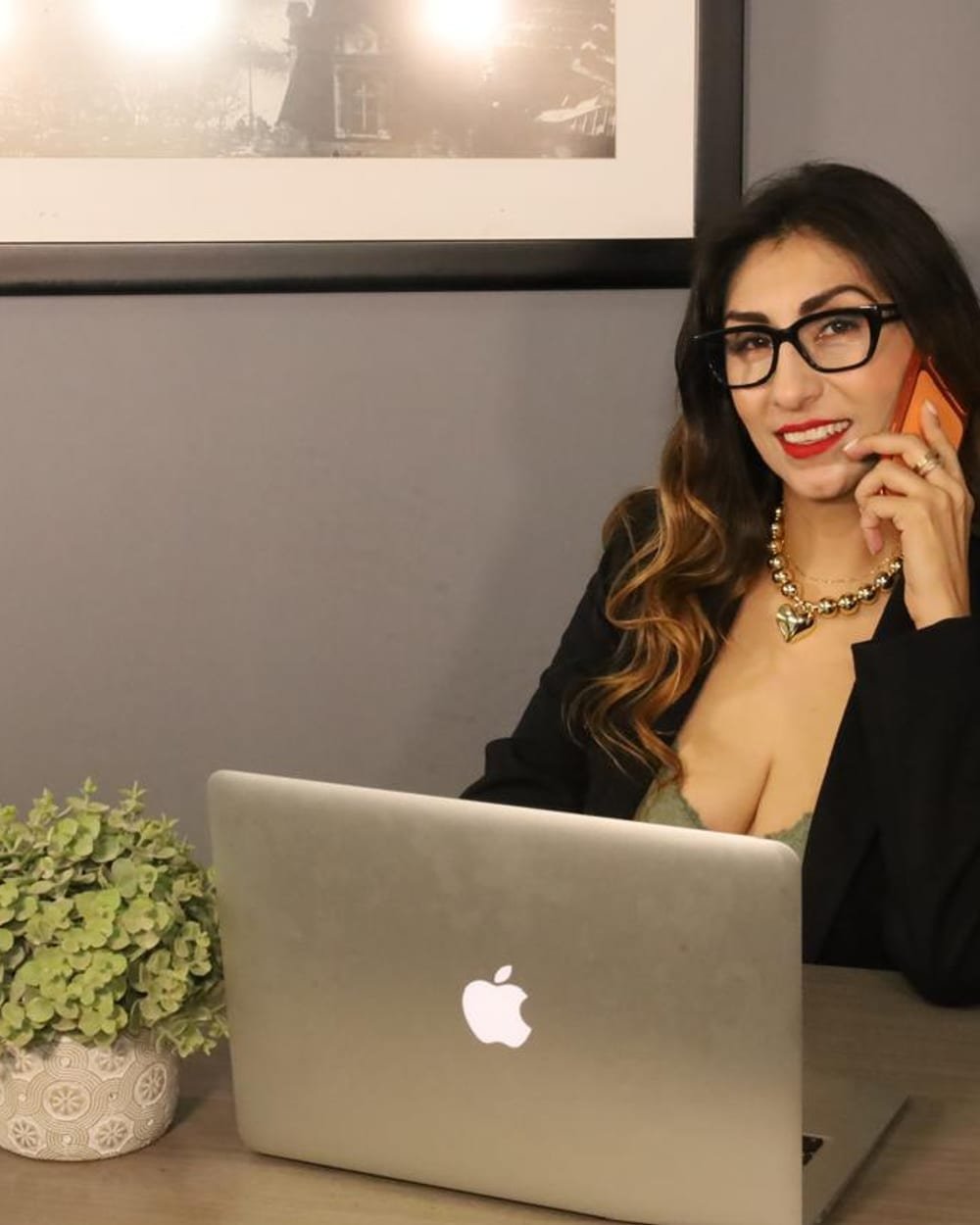 Claudia Orozco durante una consulta, sonriendo frente a su laptop